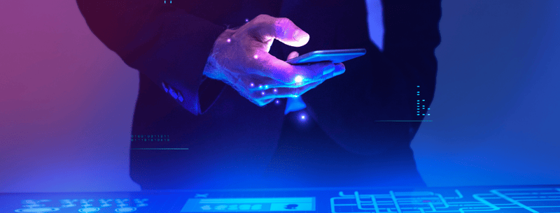 Mano de persona sosteniendo un celular en un entorno digital y tecnológico